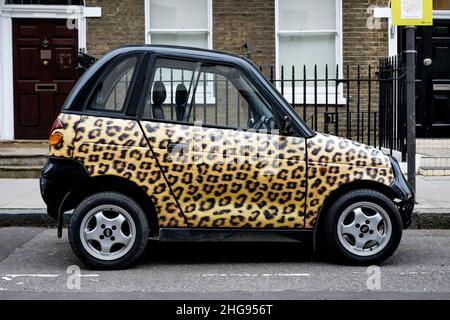 Ein Reva G-Wiz Elektroauto mit Leopardendruck-Design-Verkleidung, geparkt auf der Straße, London, Großbritannien Stockfoto