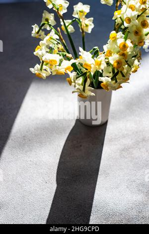 Blick von oben auf einen Haufen Narzissblüten auf einem Tisch im Sonnenlicht Stockfoto