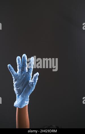 Mann Arzt mit medizinischen Handschuhen isoliert auf schwarz Stockfoto