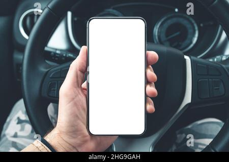 Smartphone-Mockup im männlichen Fahrer übergibt Auto-Lenkrad, selektiver Fokus Stockfoto