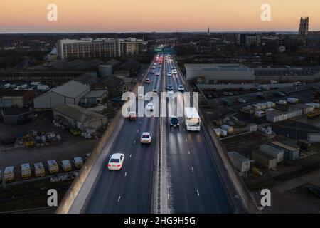 Luftaufnahme des Verkehrs, der nachts während der abendlichen Hauptverkehrszeit eine Stadt auf einer Autobahnüberführung verlässt Stockfoto