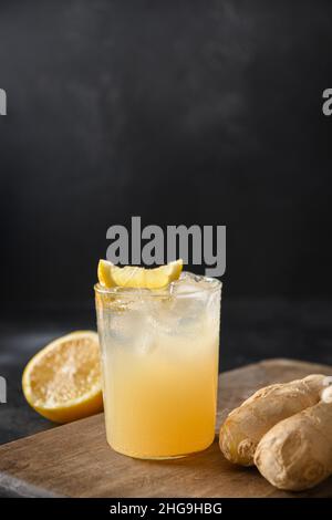 Hausgemachter Kombucha mit Honig, Zitrone und Ingwer auf schwarzem Hintergrund. Heathy organic probiotic Drink. Vertikales Format. Nahaufnahme. Stockfoto