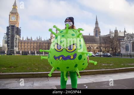 London, Großbritannien. 18th Januar 2022. Während der Impfkampagne gegen die Welt trägt ein Aktivist ein Coronavirus-Kostüm.Aktivisten von ONE UK, einer globalen Bewegung, die sich bis 2030 für die Beendigung extremer Armut und vermeidbarer Krankheiten eingesetzt hat, veranstalteten eine Kampagne in Coronavirus- und Ärztekostümen auf dem Parliament Square. Aufruf an die britische Regierung und die Staats- und Regierungschefs der Welt, Impfstoffe mit Ländern mit niedrigem Einkommen auszutauschen, die Welt zu impfen und die COVID-19-Pandemie zu beenden. (Foto: Vuk Valcic/SOPA Images/Sipa USA) Quelle: SIPA USA/Alamy Live News Stockfoto