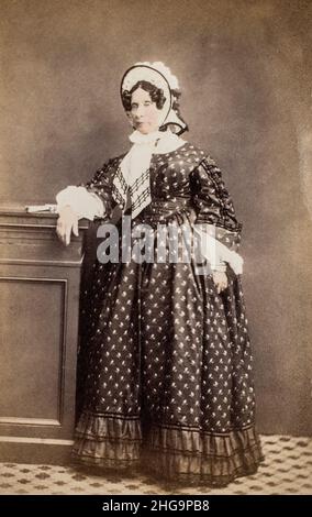 Viktorianische Dame steht, aus einer handkolorierten Carte de Visite, die um 1880 in Brighton aufgenommen wurde Stockfoto