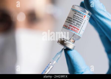 Ein Mitarbeiter im Gesundheitswesen nimmt eine Dosis aus einer Ampulle mit dem Impfstoff Moderna Covid-19, die im Impfzentrum angeordnet wurde. Stockfoto