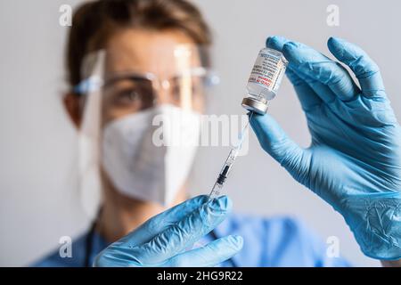 Eine medizinische Mitarbeiterin nimmt eine Dosis aus einer Ampulle mit dem Impfstoff Moderna Covid-19, die im Impfzentrum angeordnet wurde. Stockfoto