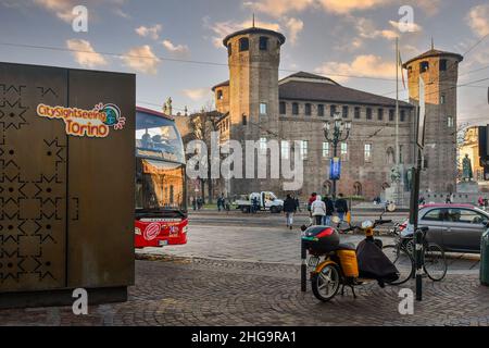 Ein Touristenbus mit Stadtbesichtigung auf dem Piazza Castello Platz vor dem Casaforte von Acaja im Zentrum von Turin bei Sonnenuntergang, Piemont, Italien