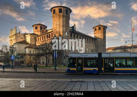 Eine Straßenbahn, die vor Casaforte von Acaja und dem Palazzo Madama auf dem Piazza Castello Platz bei Sonnenuntergang, Turin, Piemont, Italien, vorbeifährt Stockfoto
