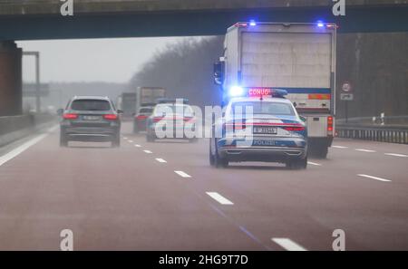 18. Januar 2022, Sachsen-Anhalt, Dessau-Roßlau: Ein Geldtransporter fährt im Konvoi mit drei Polizeifahrzeugen als Eskorte auf der Autobahn A9 bei Dessau. Foto: Jan Woitas/dpa-Zentralbild/dpa Stockfoto