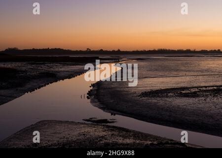 Sonnenuntergang, Dämmerung, über Pagham Harbour von der Nordwand neben Salthouse aus gesehen, Blick auf White's Creek, Gezeiten, Winter, Sussex, Großbritannien Stockfoto