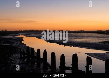 Sonnenuntergang, Dämmerung, über Pagham Harbour von der Nordwand neben Salthouse aus gesehen, Blick auf White's Creek, Gezeiten, Winter, Sussex, Großbritannien Stockfoto