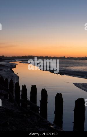 Sonnenuntergang, Dämmerung, über Pagham Harbour von der Nordwand neben Salthouse aus gesehen, Blick auf White's Creek, Gezeiten, Winter, Sussex, Großbritannien Stockfoto