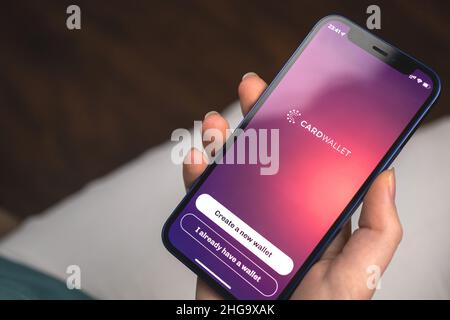 Kharkov, Ukraine - 10. Januar 2022: Frau nutzt CardWallet ADA Cardano Wallet App. Hand mit Apple iPhone 12, Handy-Bildschirm mit Logo Stockfoto