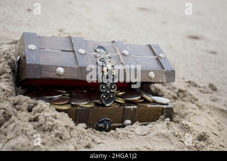 Truhe mit Geld am Strand Stockfoto