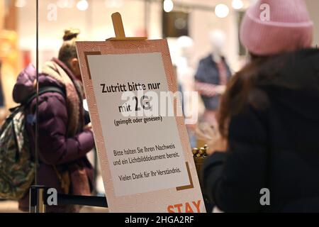 Bayern kippt die Regel von 2G im Einzelhandel. Archivfoto: Kontrolle der Regel von 2G im Handel in Bayern. Ein Schild am Eingang eines Ladens weist auf die Regel von 2G hin. Einlass nur mit FFP2 Maske und 2g Nachweis, Impfpass und Ausweisdokument bereit, Einlass nur für geimpfte oder wiedergeborene Kunden, Personen, Impfpass und Ausweiskarte bereit. Smartphone, Handy. Â Stockfoto