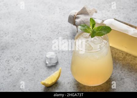 Kombucha mit Zitrone auf grauem Hintergrund. Bio gesundes probiotisches Getränk. Nahaufnahme. Stockfoto