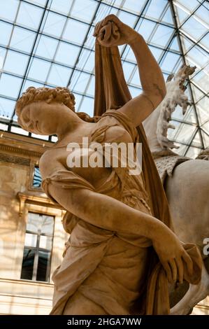 Eines der Marly-Pferde mit dem Titel „Pferd, das von einem Bräuchen gehalten wird“ im Marly-Hof des Louvre-Museums in Paris, Frankreich. Stockfoto