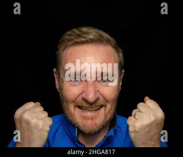 50 etwas männlich, Bart und dunkelblonde Haare tragen blaues Hemd Stockfoto
