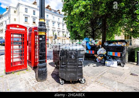 London, Großbritannien - 21. Juni 2018: Straße Bürgersteig Straße in Pimlico Westminster Bezirk mit roter Telefonzelle und Müllcontainer mit schmutzigem Müll r Stockfoto