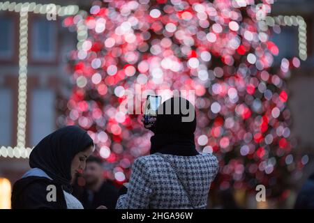 In Covent Garden, im Zentrum von London, fotografieren die Menschen am Nachrichtenabend festliche Lichter. Stockfoto