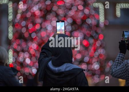 In Covent Garden, im Zentrum von London, fotografieren die Menschen am Nachrichtenabend festliche Lichter. Stockfoto