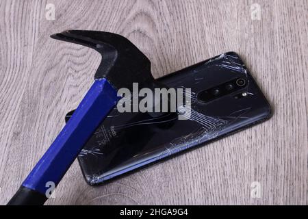 Weißrussland, Novopolotsk - 19. januar 2022: Hammer bricht xiaomi Handyhülle aus nächster Nähe Stockfoto