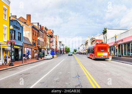 Washington DC, USA - 18. August 2021: Georgetown M Straßenlandschaft mit Geschäften Geschäfte farbenfrohe Gebäude in trendiger Nachbarschaft mit Bus im Verkehr Stockfoto