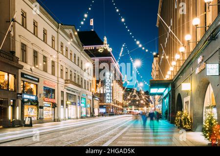 Helsinki, Finnland. Nacht der Aleksanterinkatu Straße mit Eisenbahn in Kluuvi erhalten Bezirk in Abend Weihnachten neues Jahr festliche Beleuchtung. Stockfoto