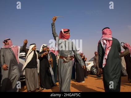 Saudische Männer tanzen während des King Abdul Aziz Camel Festivals, Provinz Riyadh, Rimah, Saudi-Arabien Stockfoto