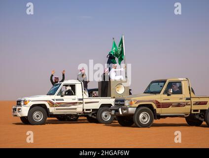 Saudische Männer folgen Kamelen mit ihren Autos während des King Abdul Aziz Camel Festivals, Provinz Riyadh, Rimah, Saudi-Arabien Stockfoto