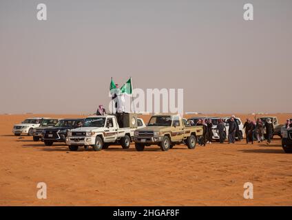 Saudische Männer folgen Kamelen mit ihren Autos während des King Abdul Aziz Camel Festivals, Provinz Riyadh, Rimah, Saudi-Arabien Stockfoto