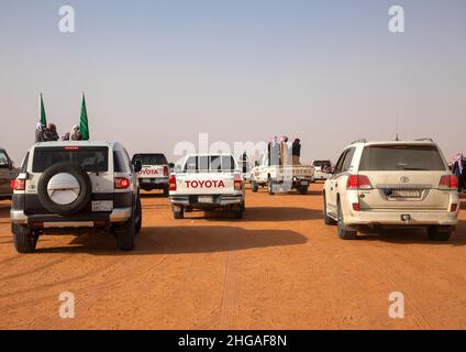 Saudische Männer folgen Kamelen mit ihren Autos während des King Abdul Aziz Camel Festivals, Provinz Riyadh, Rimah, Saudi-Arabien Stockfoto