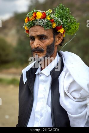 Porträt eines Blumenmanns mit einer Blumenkrone auf dem Kopf, Provinz Asir, Sarat Abidah, Saudi-Arabien Stockfoto