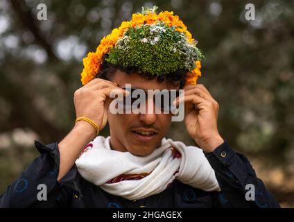 Porträt eines Blumenmanns mit einer Blumenkrone auf dem Kopf, Provinz Asir, Sarat Abidah, Saudi-Arabien Stockfoto