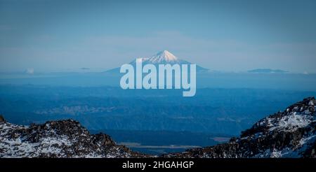 Schneebedeckter Mount Taranaki oder Egmont, ein aktiver Vulkan, von weit her im tongariro National Park, Neuseeland, betrachtet. Stockfoto