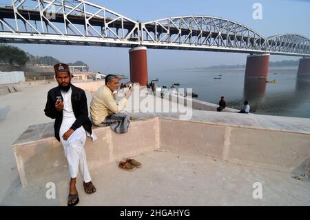 Varanasi, Indien. 19th Januar 2022. Bewohner sitzen am Ufer des Heiligen Flusses Ganga während des Anstiegs der Pandemiefälle von Covid-19 in Varanasi, Uttar Pardesh, Indien, am 19. Januar 2022. (Foto: Ravi Batra/Sipa USA) Quelle: SIPA USA/Alamy Live News Stockfoto