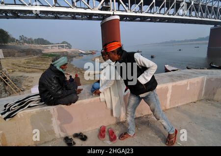 Varanasi, Indien. 19th Januar 2022. Bewohner sitzen am Ufer des Heiligen Flusses Ganga während des Anstiegs der Pandemiefälle von Covid-19 in Varanasi, Uttar Pardesh, Indien, am 19. Januar 2022. (Foto: Ravi Batra/Sipa USA) Quelle: SIPA USA/Alamy Live News Stockfoto