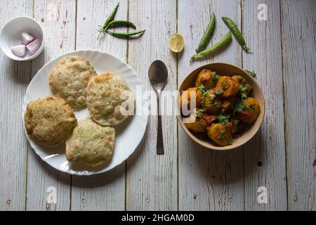 Puri oder indisches Fladenbrot serviert mit Dum aloo oder Kartoffelmasala-Soße. Draufsicht. Stockfoto