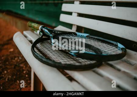 Tennisschläger liegen auf einer Bank Stockfoto
