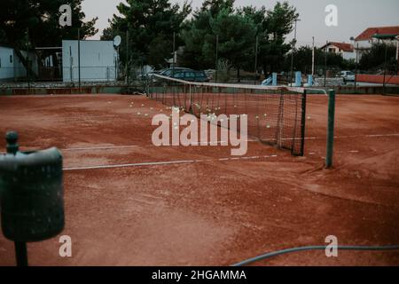 Ein großer Tennisplatz draußen, viele Bälle auf dem Boden. Sport, gesunder Lebensstil Stockfoto