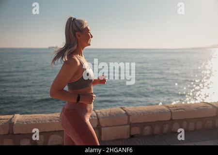 Erwachsene starke Frau, die am Wasser trainiert Stockfoto