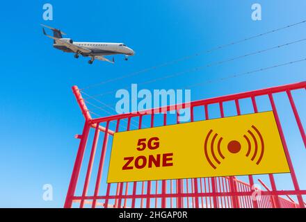 5G Schild am Umzäunungszaun des Flughafens mit Flugzeugen, Flugzeug auf Landeanflug. Stockfoto