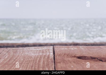 Abstrakte Natur Sommer oder Frühling Meer Meer Hintergrund. Kleine Wellen auf der goldenen, warmen Wasseroberfläche verwischen sich in Bewegung mit Bokeh-Lichtern vom Sonnenuntergang. Urlaub Stockfoto