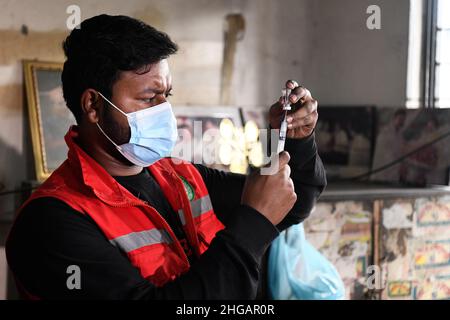 Dhaka, Bangladesch. 19th Januar 2022. Ein Mitarbeiter des Gesundheitswesens bereitet sich auf die Verabreichung eines Fahrers für den öffentlichen Verkehr vor, indem er die Vacccine Covid-19 am Busbahnhof Mohakhali in der Hauptstadt abgeschossen hat.im Rahmen des Crashprogramms werden Fahrer und Arbeitnehmer des öffentlichen Verkehrs ab der Hauptstadt mit einer Coronavirus-Impfung impfen. Die Impfung erfolgt durch Vorlage des nationalen Personalausweises oder der Geburtsregistrierung. Kredit: SOPA Images Limited/Alamy Live Nachrichten Stockfoto