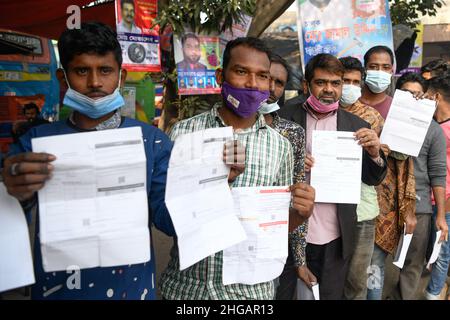 Dhaka, Bangladesch. 19th Januar 2022. Fahrer und Mitarbeiter des öffentlichen Verkehrs, die in einer Schlange stehen, zeigen ihre Identifikationsdaten an, während sie auf die Impfung am Busbahnhof Mohakhali in der Hauptstadt warten.im Crashprogramm werden Fahrer und Arbeiter des öffentlichen Verkehrs ab der Hauptstadt mit einer Coronavirus-Impfung impft. Die Impfung erfolgt durch Vorlage des nationalen Personalausweises oder der Geburtsregistrierung. Kredit: SOPA Images Limited/Alamy Live Nachrichten Stockfoto