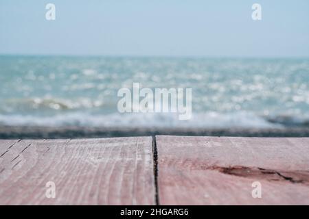 Abstrakte Natur Sommer oder Frühling Meer Meer Hintergrund. Kleine Wellen auf der goldenen, warmen Wasseroberfläche verwischen sich in Bewegung mit Bokeh-Lichtern vom Sonnenuntergang. Urlaub Stockfoto