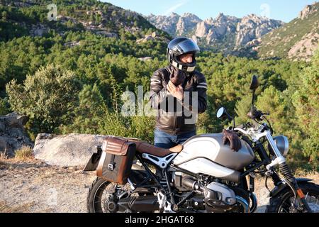 Ein Biker zieht Handschuhe an, bevor er auf dem Motorrad fährt Stockfoto