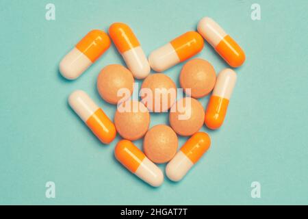 Pillen auf blauem Hintergrund. Verschiedene pharmazeutische Medikamente Pillen, Tabletten und Kapseln, Gesundheit Makro. Herztabletten. Herz aus bunten Pillen auf b Stockfoto