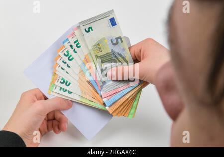 Hand, Geldumschlag, Symbol-Foto-Zahlungspaket, Studioaufnahme Stockfoto