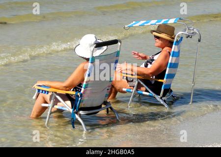 Touristen auf Sonnenliege entspannen im Wasser, Fort Myers Beach, Florida, USA Stockfoto